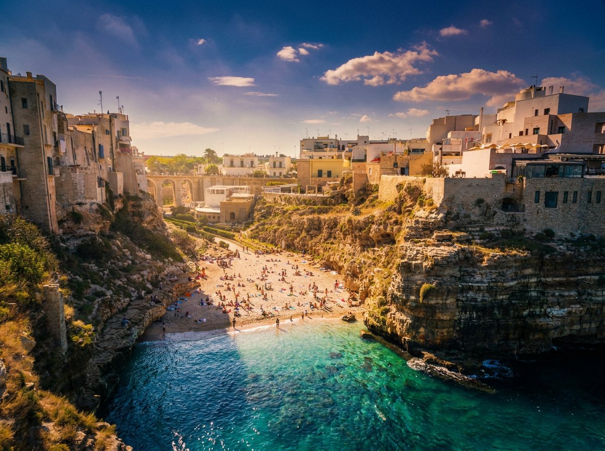 A turquoise cove below the cliffside town of Polignano a Mare
